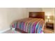 Bedroom with a colorful quilt on the bed and a small side table with lamp and personal items at 511 Woodlawn Blvd, Orlando, FL 32801