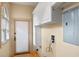 Functional laundry room with a window, cabinets, and a door to the exterior at 511 Woodlawn Blvd, Orlando, FL 32801