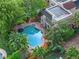 Aerial perspective of a beautiful pool area surrounded by lush greenery, palm trees, and meticulous brickwork at 511 Woodlawn Blvd, Orlando, FL 32801