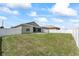 Spacious backyard featuring green grass, white fencing, and covered patio area at 5707 Fischer Dr, Lakeland, FL 33812