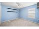 Bedroom with ceiling fan, neutral carpet, blue walls and large window at 5707 Fischer Dr, Lakeland, FL 33812