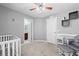 Bedroom featuring a crib, glider, accent wall, and access to an ensuite bathroom at 5707 Fischer Dr, Lakeland, FL 33812