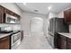 Kitchen featuring stainless steel appliances, dark wood cabinets and an open view to another room at 5707 Fischer Dr, Lakeland, FL 33812