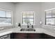 Kitchen sink beneath bright windows, paired with dark cabinets and neutral countertops, offering functionality at 5707 Fischer Dr, Lakeland, FL 33812
