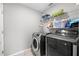 Well-equipped laundry room with modern washer, dryer, and overhead shelving at 5707 Fischer Dr, Lakeland, FL 33812