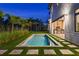Exterior of a backyard featuring a rectangular pool, stepping stone pavers, privacy landscaping and an outdoor kitchen at 5762 Emerington Cres, Orlando, FL 32819