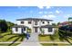 Beautiful modern two-story home with a paver driveway, manicured landscaping, and a striking front entrance, under a sunny blue sky at 5762 Emerington Cres, Orlando, FL 32819