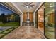 Outdoor patio with stainless steel kitchen, grill, stone flooring and views of the pool and lush landscaping at 5762 Emerington Cres, Orlando, FL 32819