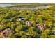 Overhead shot of a lakeside neighborhood featuring mature trees and beautiful luxury homes with tile roofs at 6143 Cartmel Ln, Windermere, FL 34786