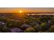 Scenic aerial view of a neighborhood with a lake in the distance at sunset at 6143 Cartmel Ln, Windermere, FL 34786