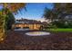 Expansive backyard featuring a trampoline, covered patio, pool and slide, and lush landscaping for the perfect outdoor oasis at 6143 Cartmel Ln, Windermere, FL 34786