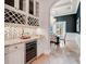 Bright bar area with a beverage cooler and a view of a dining room with a chandelier and natural light at 6143 Cartmel Ln, Windermere, FL 34786