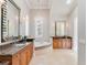 Bright and open bathroom featuring dual vanities, a soaking tub, a chandelier, and lots of natural light at 6143 Cartmel Ln, Windermere, FL 34786