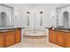 Bright bathroom featuring dual vanities, tub, chandelier and marble countertops at 6143 Cartmel Ln, Windermere, FL 34786