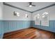 A bedroom with hardwood floors, wainscoting, and natural light from multiple windows at 6143 Cartmel Ln, Windermere, FL 34786