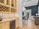 A bar area with a wine refrigerator, that opens up to a dining room at 6143 Cartmel Ln, Windermere, FL 34786