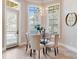 Cozy dining nook illuminated by a chandelier and natural light from windows and door with plantation shutters at 6143 Cartmel Ln, Windermere, FL 34786