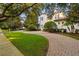 Circular driveway leading to a grand estate with lush landscaping and mature trees at 6143 Cartmel Ln, Windermere, FL 34786
