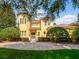 Stunning two-story home with a turret, manicured landscaping, and a paved driveway at 6143 Cartmel Ln, Windermere, FL 34786