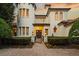 Elegant two-story home with a turret, manicured landscaping, and a paved walkway leading to the gated entrance at 6143 Cartmel Ln, Windermere, FL 34786