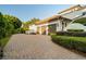 Three-car garage with a paver driveway and well-manicured landscaping at 6143 Cartmel Ln, Windermere, FL 34786
