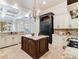 Spacious kitchen with large island, custom cabinets, granite countertops, and black refrigerator at 6143 Cartmel Ln, Windermere, FL 34786