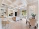 Open concept living room with coffered ceiling, built-ins, bar seating, and dining space at 6143 Cartmel Ln, Windermere, FL 34786