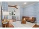 Sitting room with a light brown leather couch, hardwood floors, a decorative chandelier, and blue patterned wallpaper at 6143 Cartmel Ln, Windermere, FL 34786