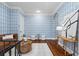 Sitting room with brown leather couch, hardwood floors, blue patterned wallpaper, and an art piece on the wall at 6143 Cartmel Ln, Windermere, FL 34786