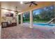 Beautiful covered patio boasts a built-in grill, TV, ceiling fans, and a stunning pool with a slide for ultimate outdoor living at 6143 Cartmel Ln, Windermere, FL 34786
