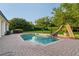 Inviting backyard pool featuring a water slide, surrounded by lush landscaping and mature trees at 6143 Cartmel Ln, Windermere, FL 34786