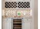 Custom wine bar features wine refrigerator, mosaic backsplash, granite countertop, and built-in wine rack at 6143 Cartmel Ln, Windermere, FL 34786