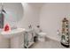 Quaint powder room featuring pedestal sink, decorative accents, and neutral tones at 6667 Alder Rd, Harmony, FL 34773