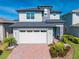 Charming two-story home with brick driveway, attached two-car garage, manicured landscaping, and welcoming front entry at 6667 Alder Rd, Harmony, FL 34773
