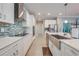 Modern kitchen with stainless steel appliances, large sink, and sleek white cabinetry at 6667 Alder Rd, Harmony, FL 34773