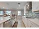 Modern kitchen featuring stainless steel appliances, a farm sink, granite countertops, and a tile backsplash at 6667 Alder Rd, Harmony, FL 34773