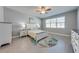 Calm main bedroom with tile flooring, ceiling fan, and white furniture at 6667 Alder Rd, Harmony, FL 34773