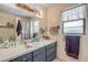 Bathroom featuring a vanity with grey cabinetry, white countertop, a large mirror, and decorative lighting at 825 Second St, Orange City, FL 32763