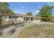 A tan single-story home features a large driveway, covered parking, and tidy landscaping at 825 Second St, Orange City, FL 32763