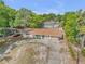 Well-maintained single-story house with a circular driveway, mature trees, and neutral color palette at 825 Second St, Orange City, FL 32763