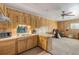 Traditional kitchen with wood cabinetry, white countertops, double basin sink, and open floor plan to living area at 825 Second St, Orange City, FL 32763