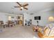An open-concept living area with a brick accent wall and carpet, flowing into the kitchen and dining area at 825 Second St, Orange City, FL 32763