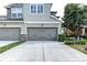 Three car garage and driveway featuring stone accents and decorative trim at 8419 Chamberlain Pl, Oviedo, FL 32765