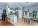 Bright kitchen open to dining area, featuring white cabinets, stainless steel appliances, and a breakfast bar at 8419 Chamberlain Pl, Oviedo, FL 32765