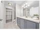 Bathroom features a gray vanity, large mirror, tiled floor, and walk-in closet at 8997 Lee Vista Blvd # 2009, Orlando, FL 32829