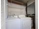 Efficient laundry area features a white washer and dryer, along with convenient overhead shelving for storage at 8997 Lee Vista Blvd # 2009, Orlando, FL 32829