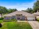 Charming single-story home featuring a well-manicured lawn and a two-car garage at 901 Cornell Ave, Clermont, FL 34711