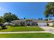 Well-maintained single-story home with manicured lawn and two-car garage at 901 Cornell Ave, Clermont, FL 34711