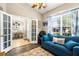 Cozy living room with a blue couch, large window, and french doors to dining room at 901 Cornell Ave, Clermont, FL 34711