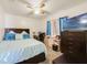 Comfortable bedroom with a ceiling fan, a cozy bed with decorative pillows, and a convenient workspace at 9231 Ventana Ln, Orlando, FL 32825